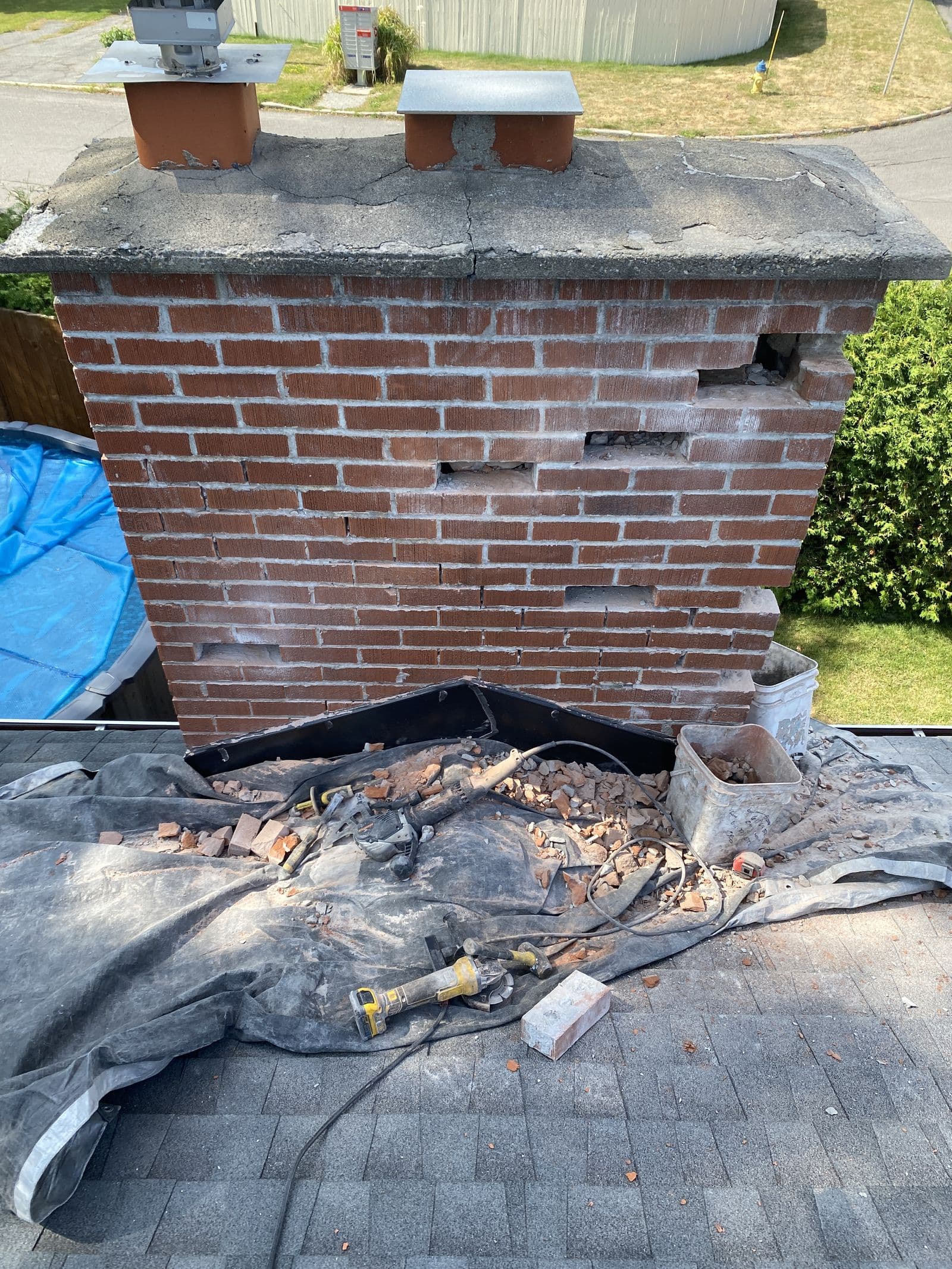 A chimney with crumbling mortar and missing bricks, before repair